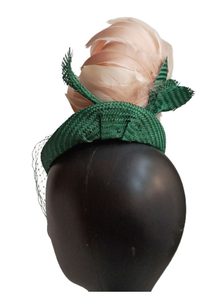 Tocado verde con velo sobre el rostro.