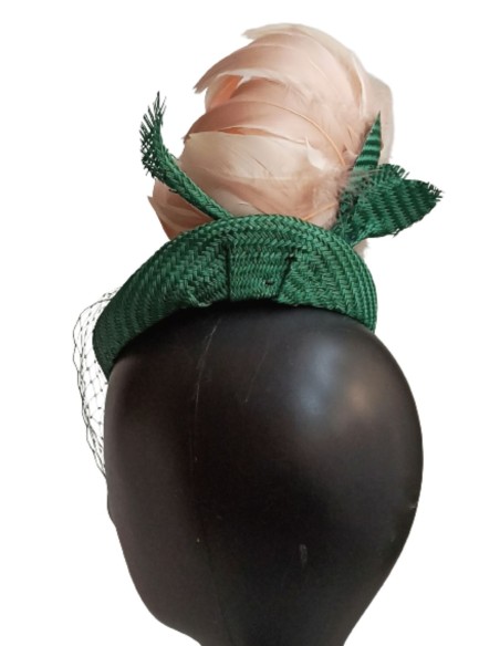 Tocado verde con velo sobre el rostro.