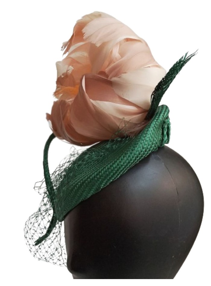 Green headpiece with feather flower in pink.