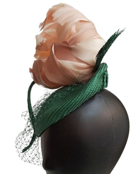 Green headpiece with feather flower in pink.