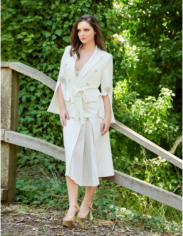 Conjunto de chaqueta blanca y falda plisada.