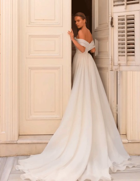 Vestido de novia con escote bandeau y cuerpo drapeado con sobrefalda desmontable