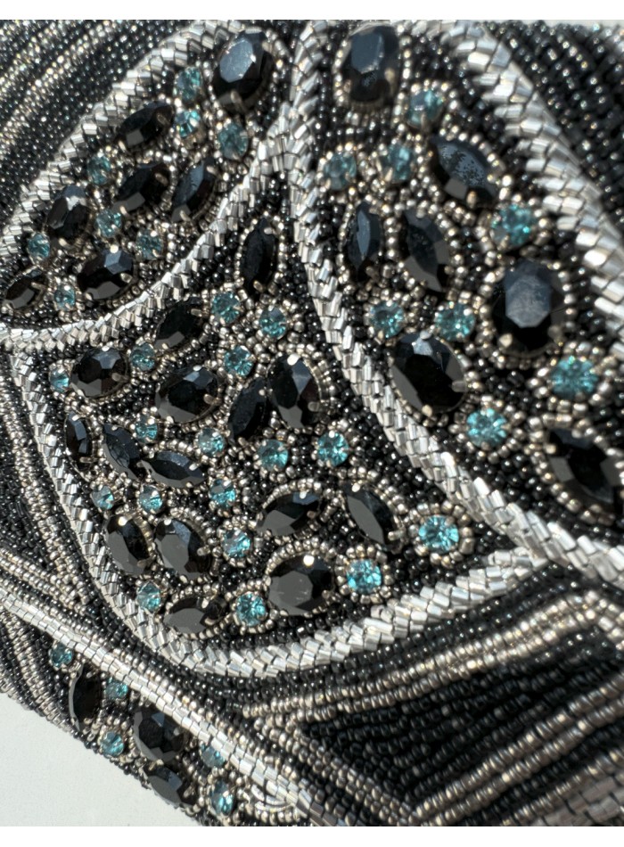 Cartera de mano de pedrería en tono negro con...
