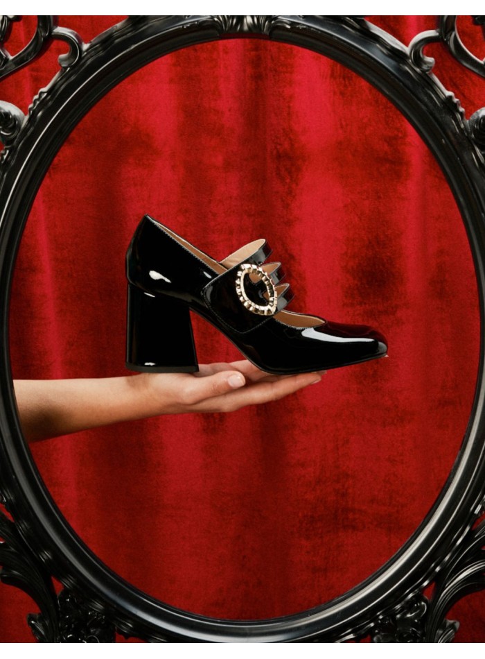 Black patent leather pumps with gold buckle...