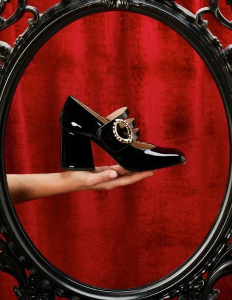 Black patent leather pumps with gold buckle fastening