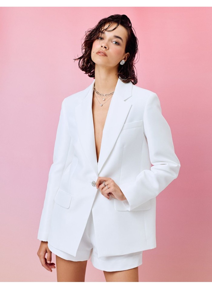 Veste blanche de style blazer avec revers et boutons ornés de pierres précieuses