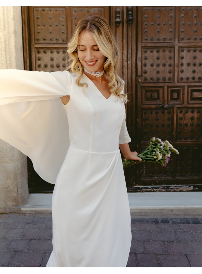 Cocktail dress with asymmetric french sleeves and cape