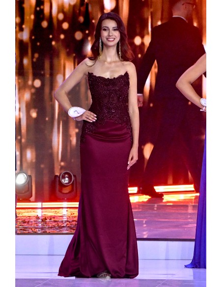 Long burgundy dress with strapless neckline and rhinestone details