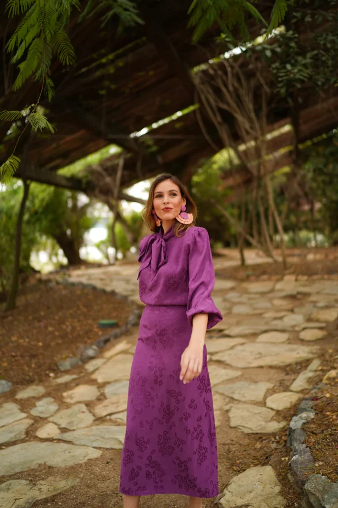 Conjunto de invitada con falda midi y blusa anudada en color malva.